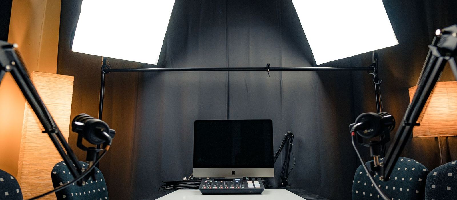 A converted room set up as a broadcast studio with microphones, lights and a computer